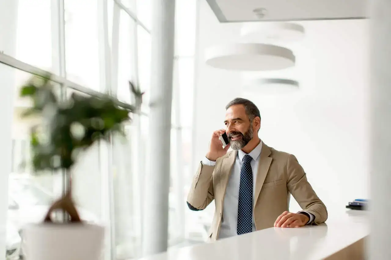 Empresario de mediana edad con teléfono móvil x1280
