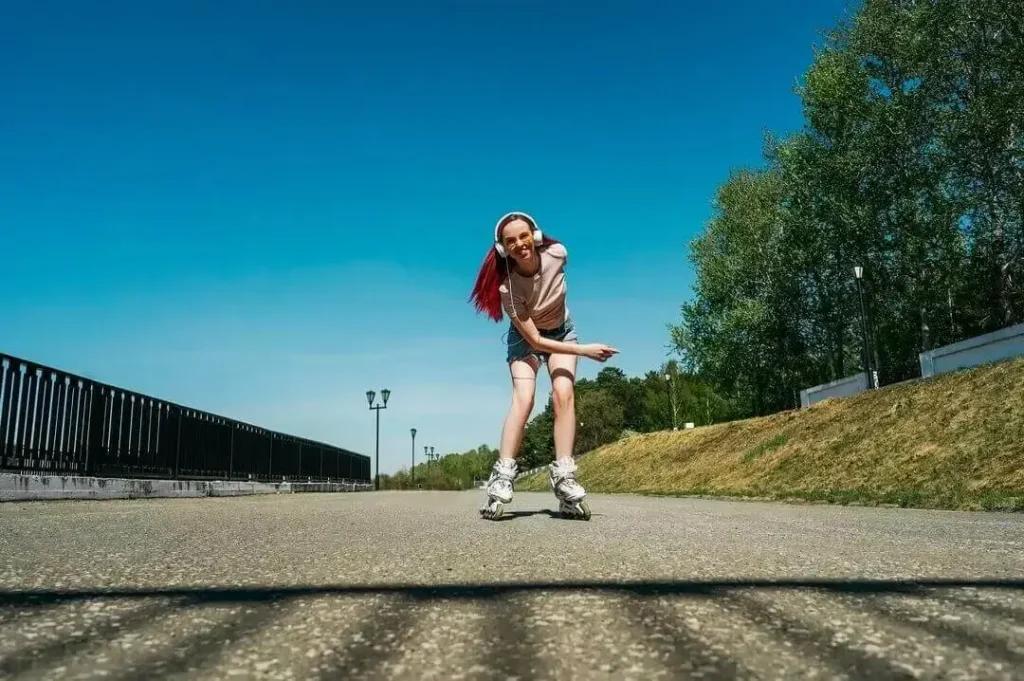 Mujer con pelo rosado corre en patines
