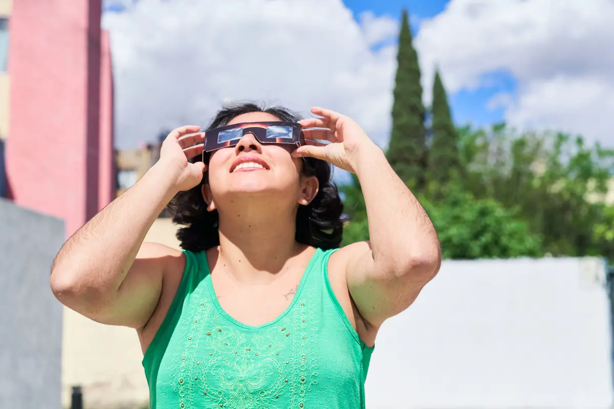 mujer latina viendo el eclipse