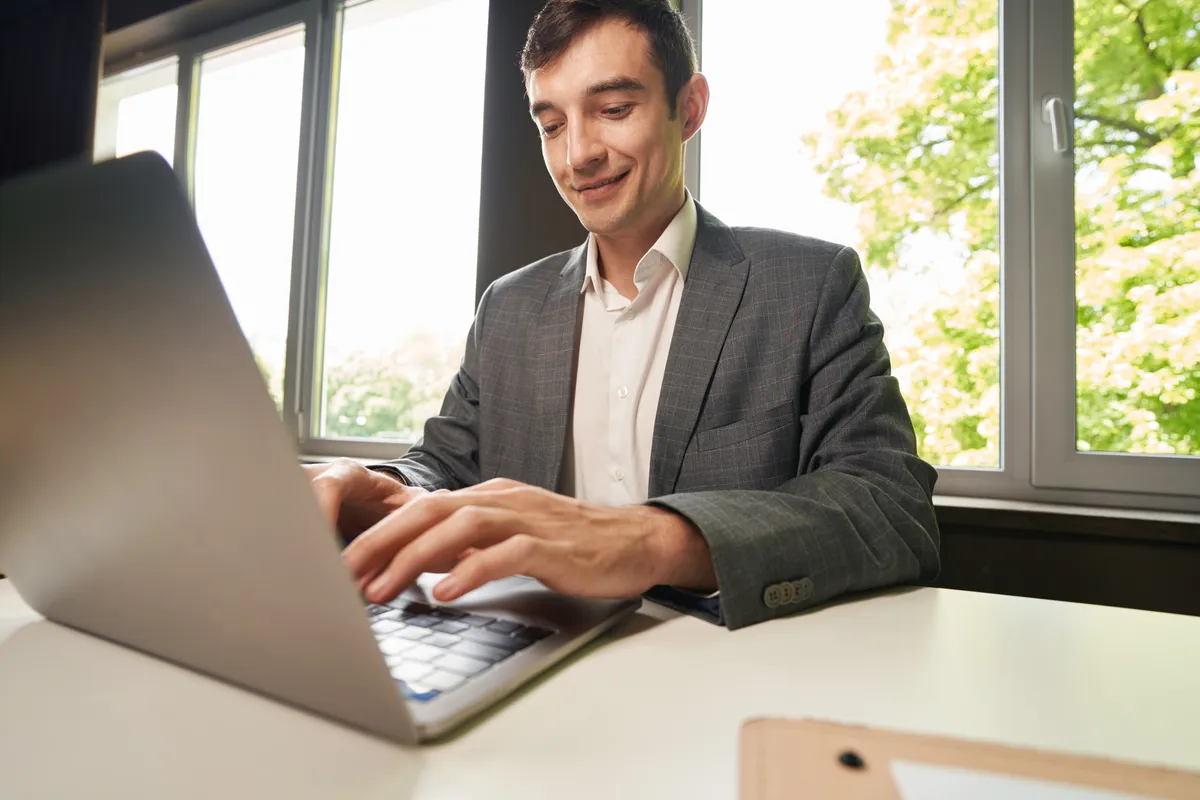 pleased-male-office-employee-typing