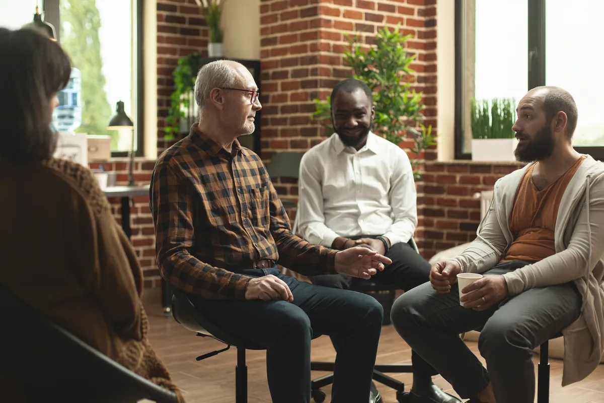 diverse-men-sitting-at-aa-group