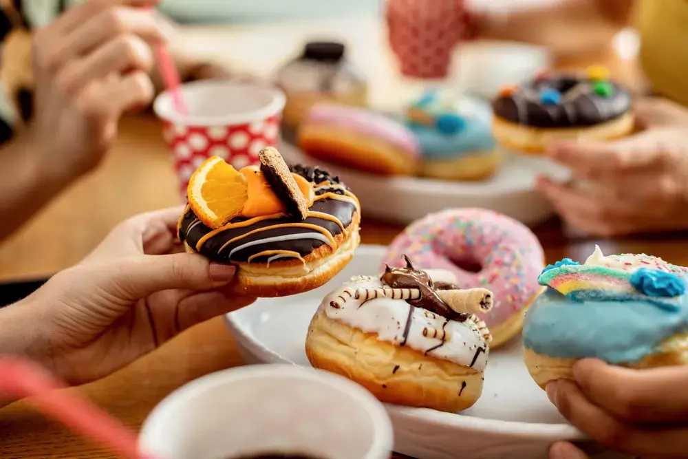 close-up-of-friends-eating-donuts