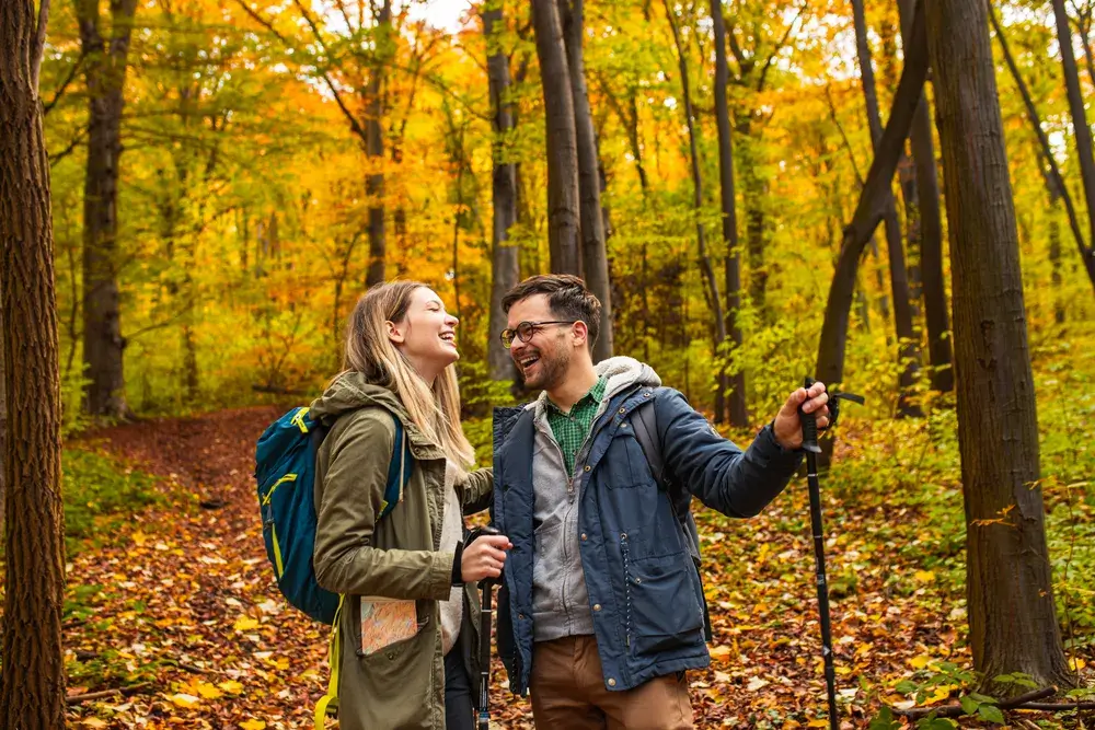 smiling-couple-with-backpacks-hiking-together