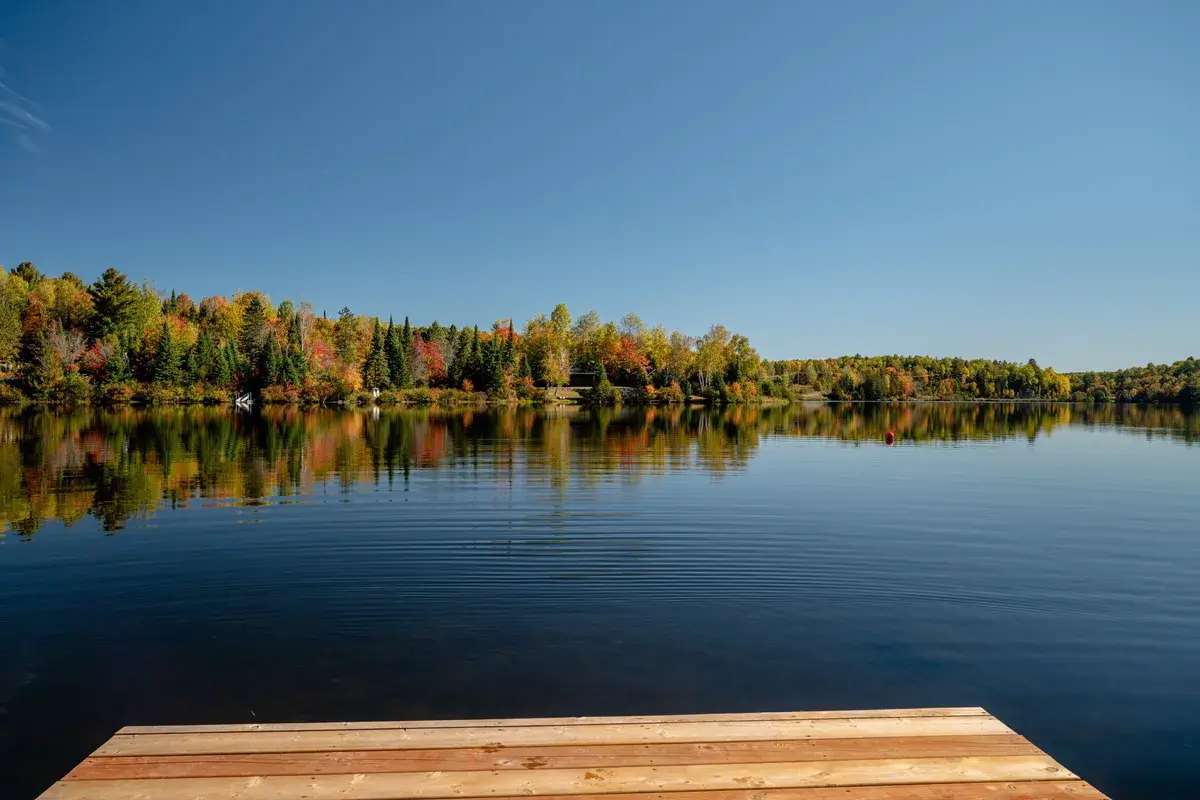 dock-and-the-autumn-trees-reflecting-on-lac-fairbu