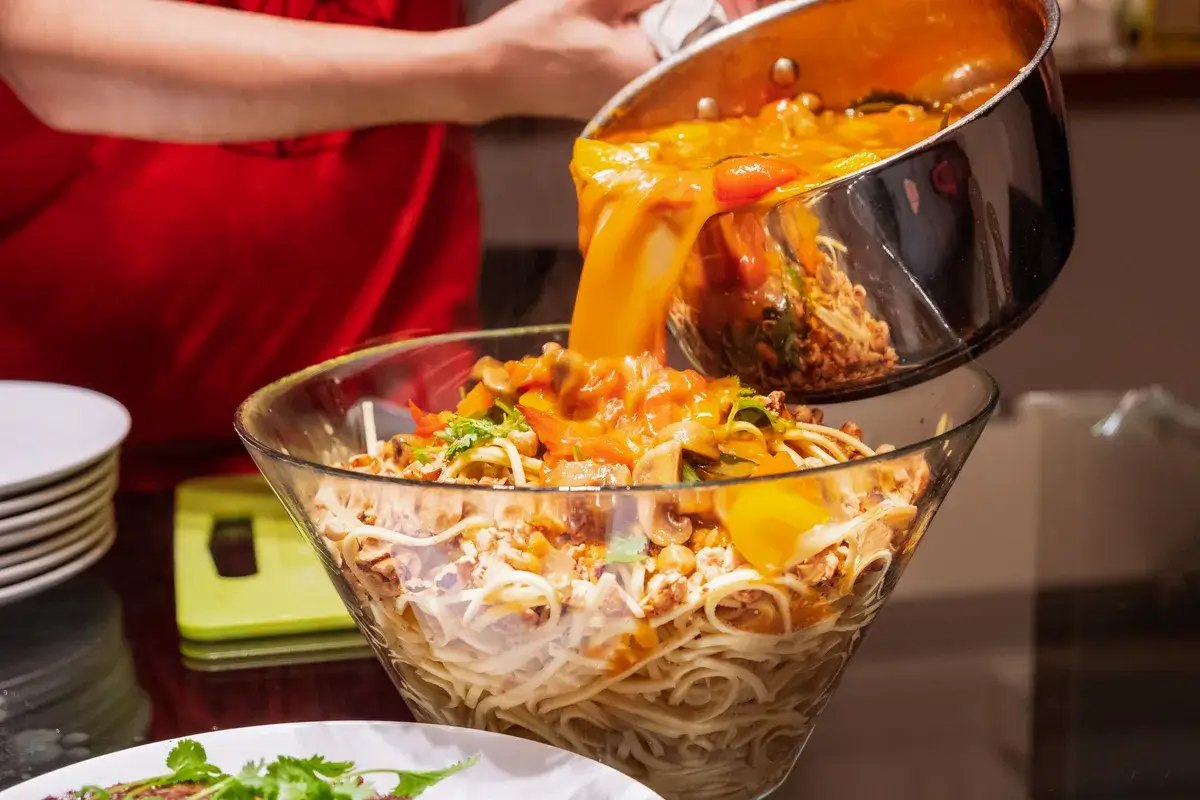 pouring-spicy-soup-mixed-on-dry-spaghetti