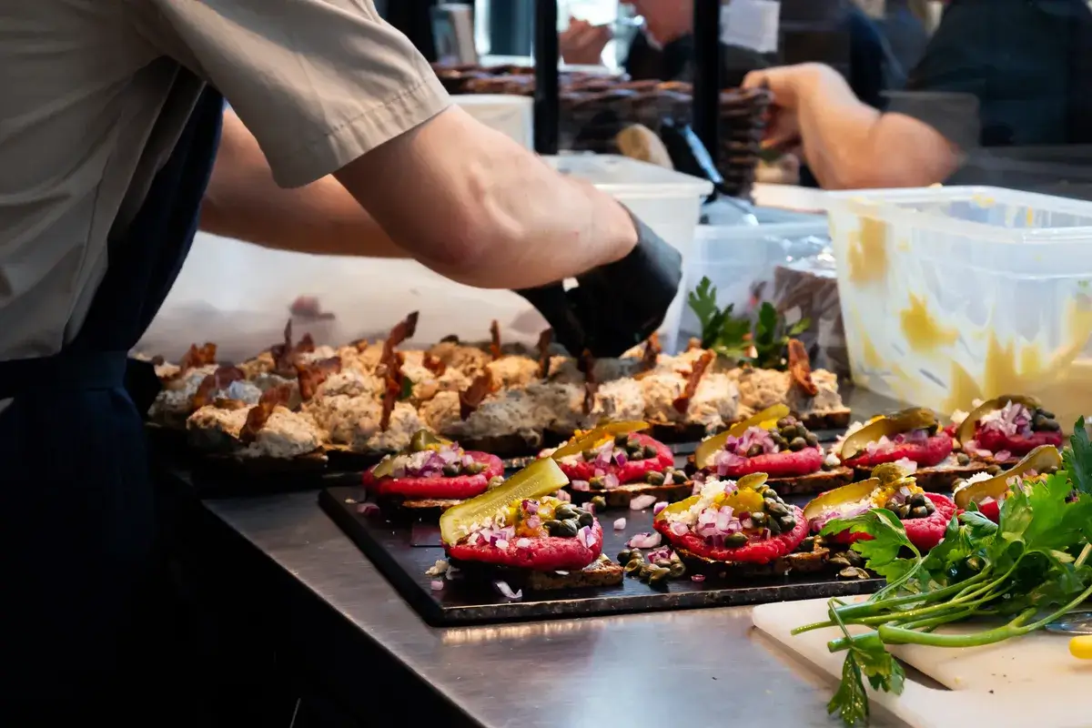 a-chef-s-hand-making-open-danish-sandwiches