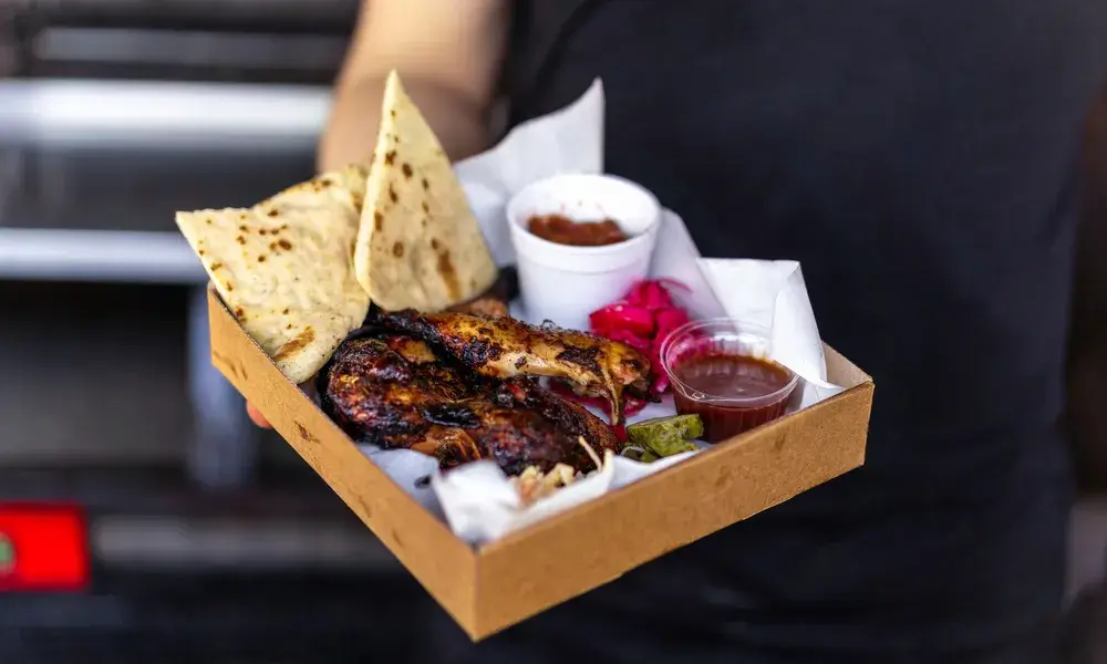 cook-holding-dish-with-meal-meat