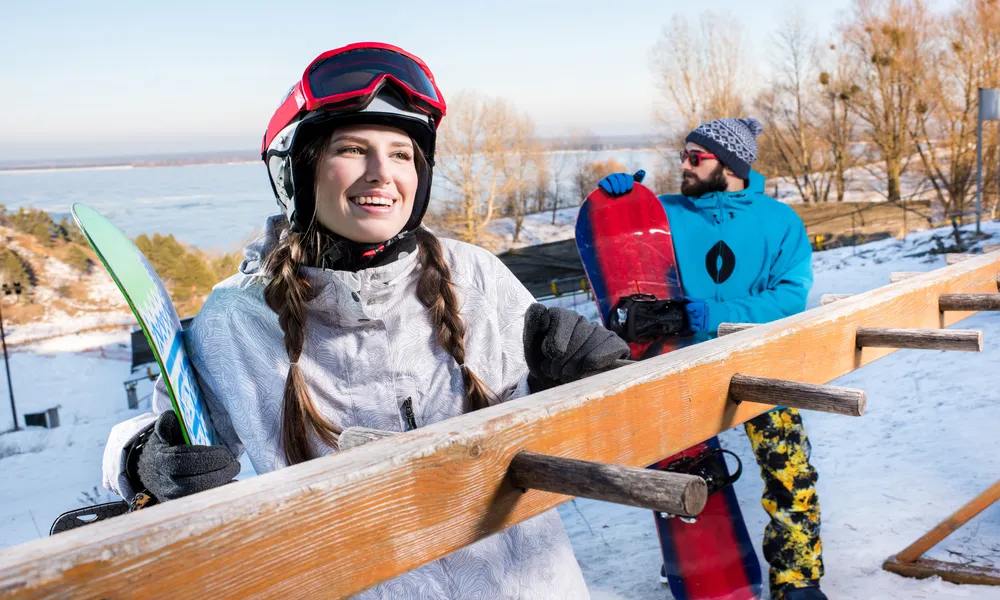 happy-young-male-and-female-snowboarders