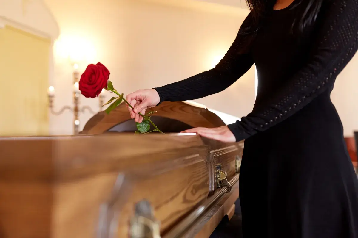 woman-with-red-roses-and-coffin-at-funeral