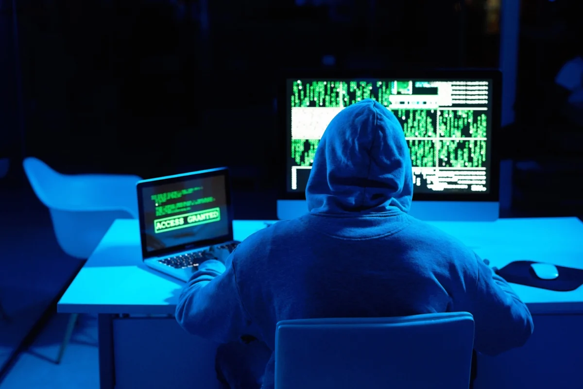 hooded-person-working-with-computer-code.webp