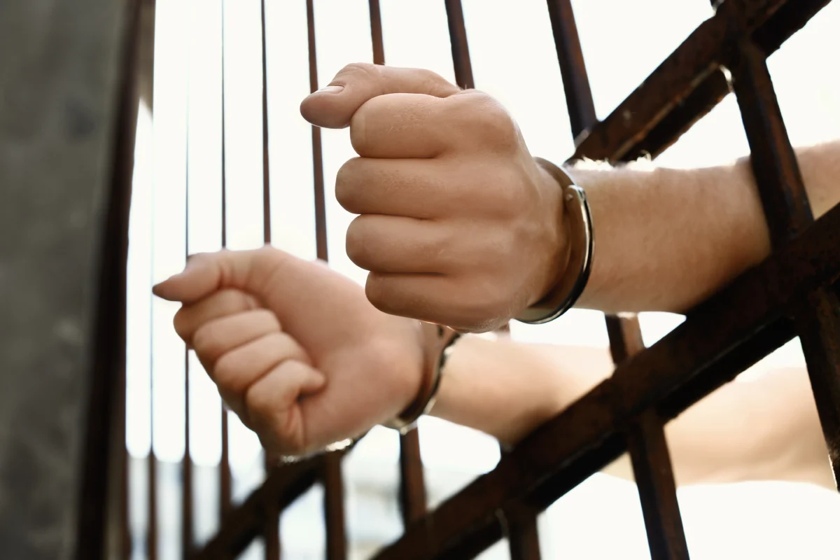 man-handcuffed-in-jail-outdoors-closeup-criminal