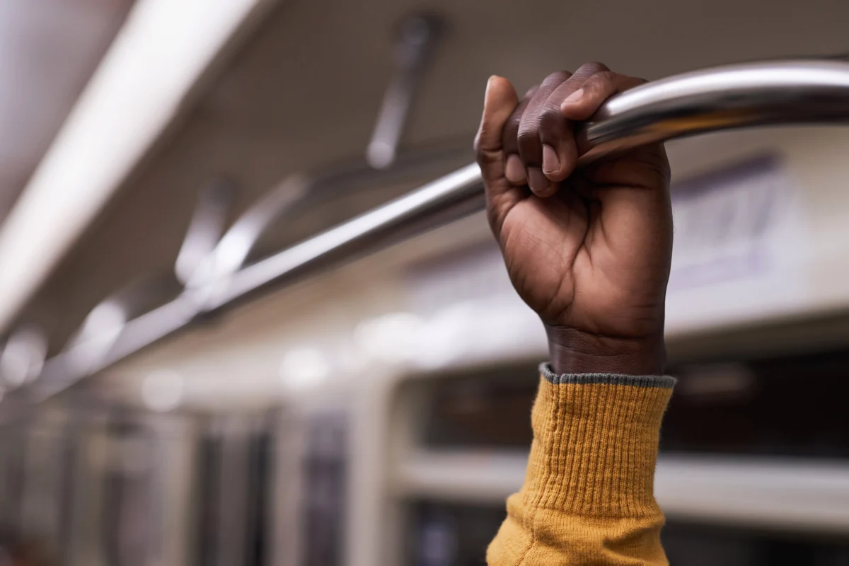 person-holding-metal-bar-on-public-transportation